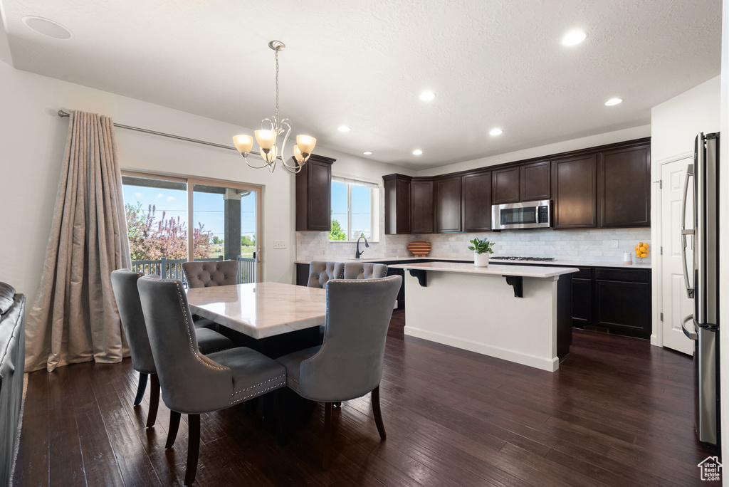 Dining space featuring recessed lighting, an inviting chandelier, and dark wood-type flooring
