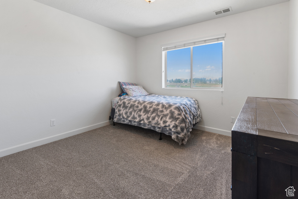 Bedroom with carpet floors, baseboards, and visible vents