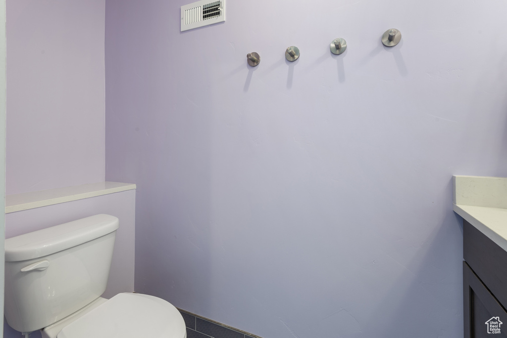 Bathroom featuring vanity, visible vents, and toilet