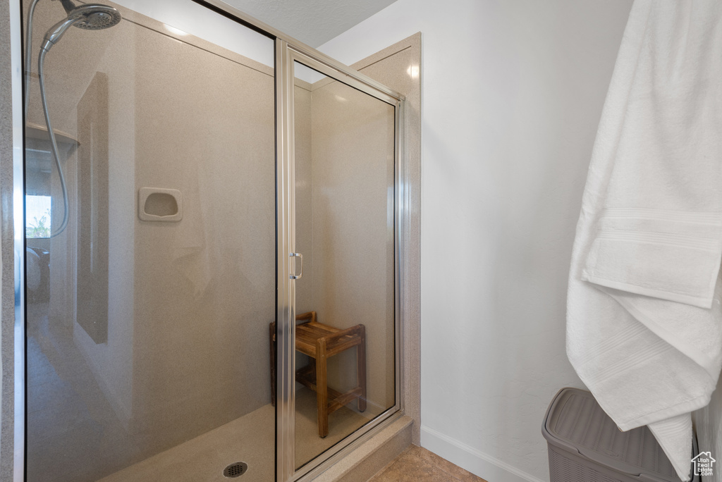 Bathroom with baseboards, tile patterned flooring, and a stall shower