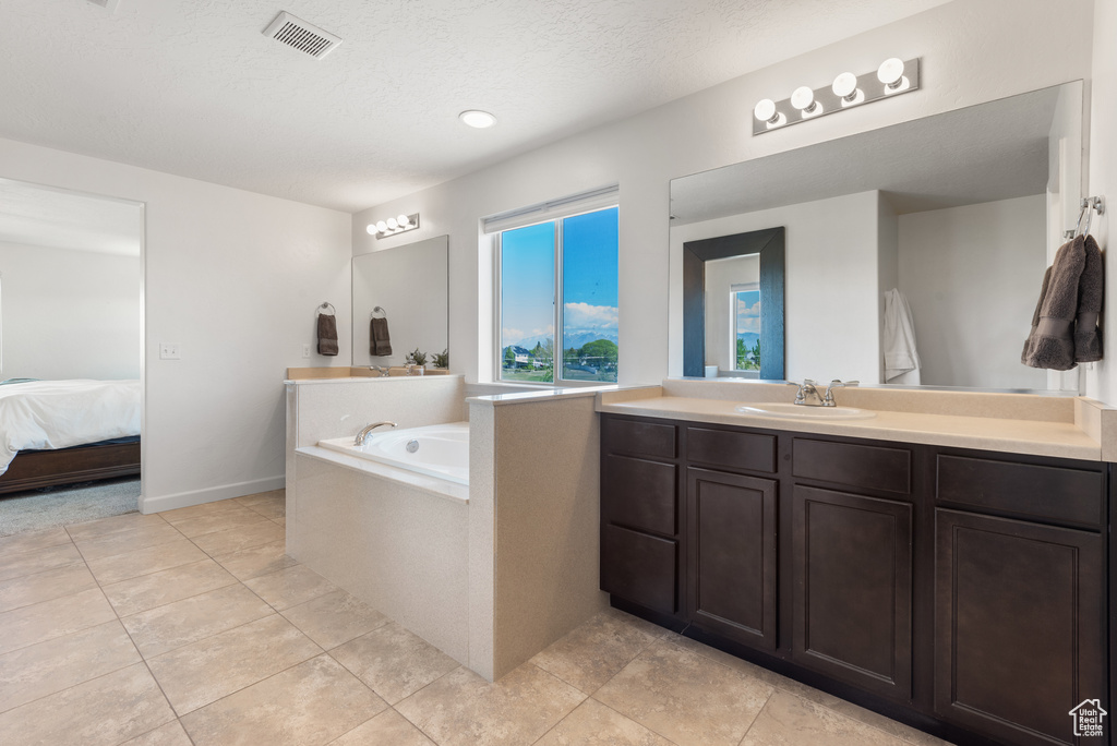Full bathroom with a bath, visible vents, vanity, tile patterned floors, and ensuite bath