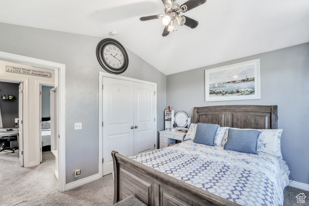 Bedroom featuring a closet, baseboards, light colored carpet, a ceiling fan, and vaulted ceiling
