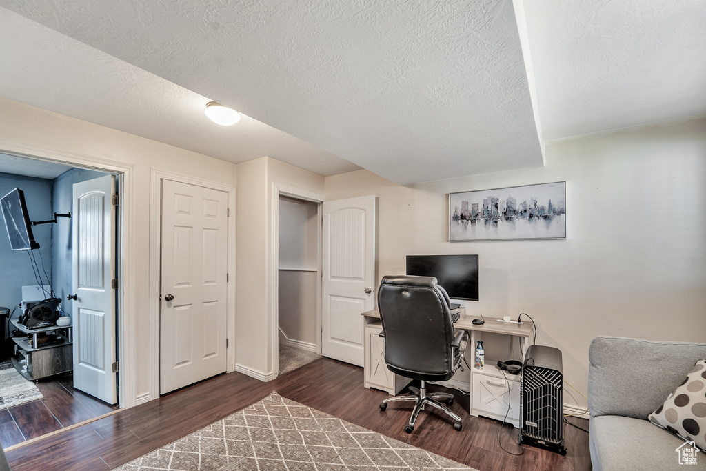 Office featuring baseboards, a textured ceiling, and dark wood finished floors