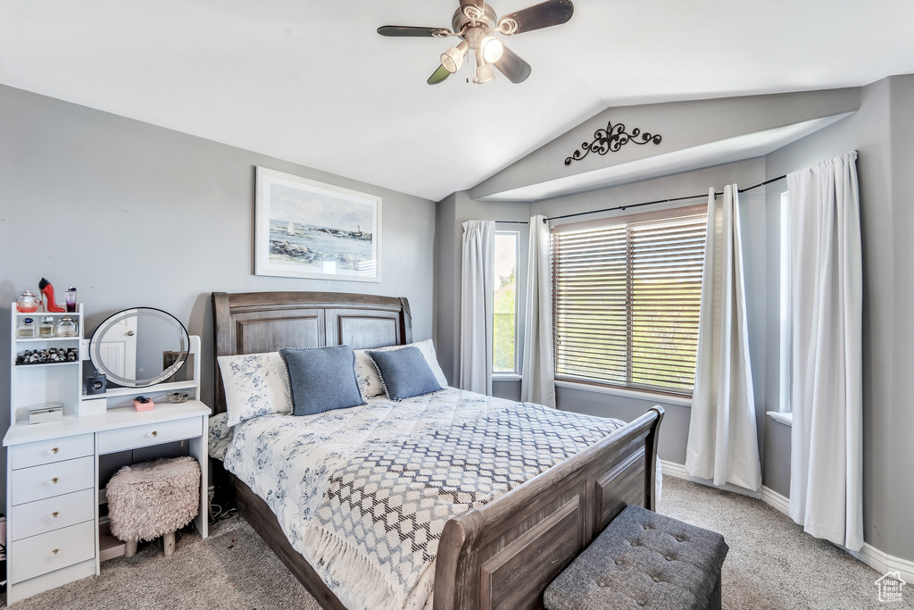 Bedroom featuring a ceiling fan, baseboards, light colored carpet, and lofted ceiling