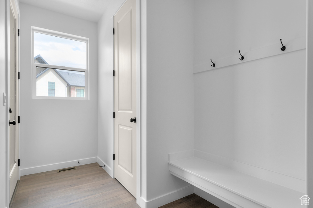Mudroom with light wood finished floors and baseboards