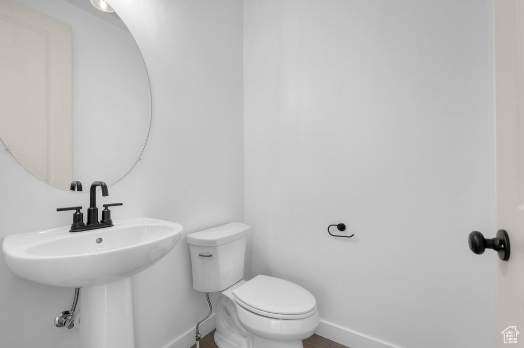 Half bathroom featuring baseboards and toilet