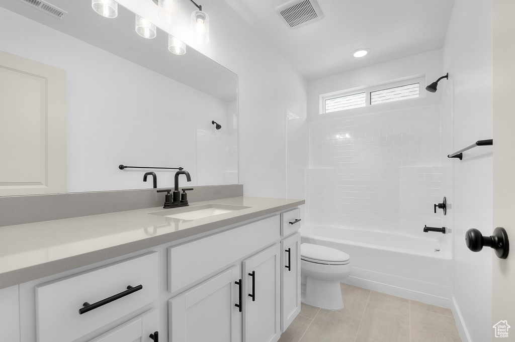 Bathroom featuring toilet, vanity, shower / tub combination, and tile patterned floors