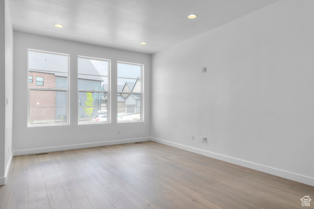Unfurnished room featuring baseboards, wood finished floors, and recessed lighting