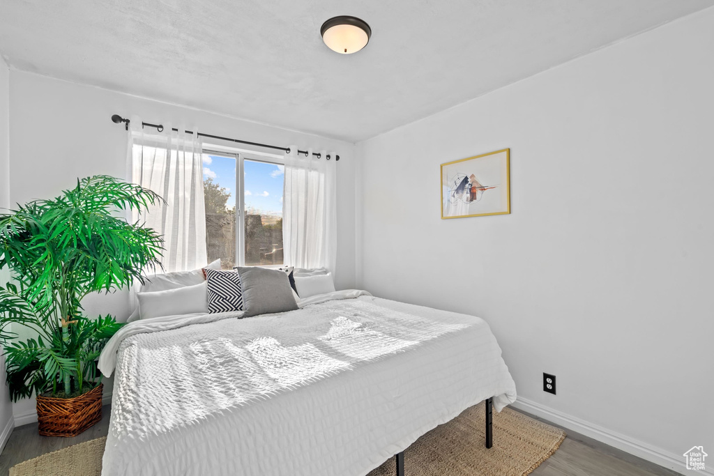Bedroom featuring baseboards and wood finished floors