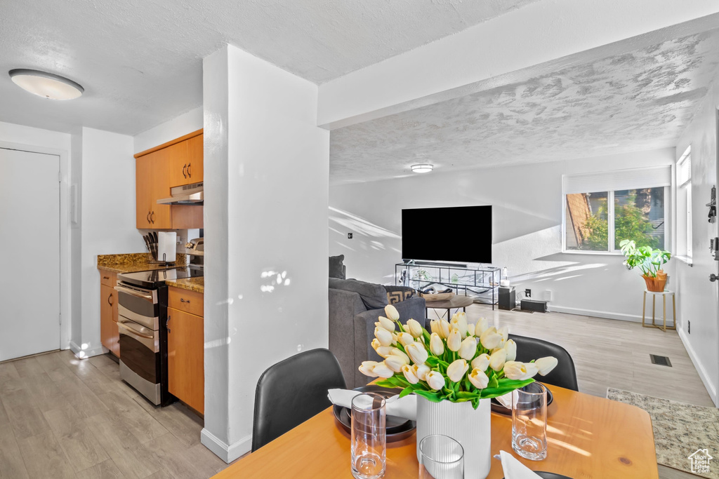 Dining room featuring visible vents, a textured ceiling, and light wood finished floors