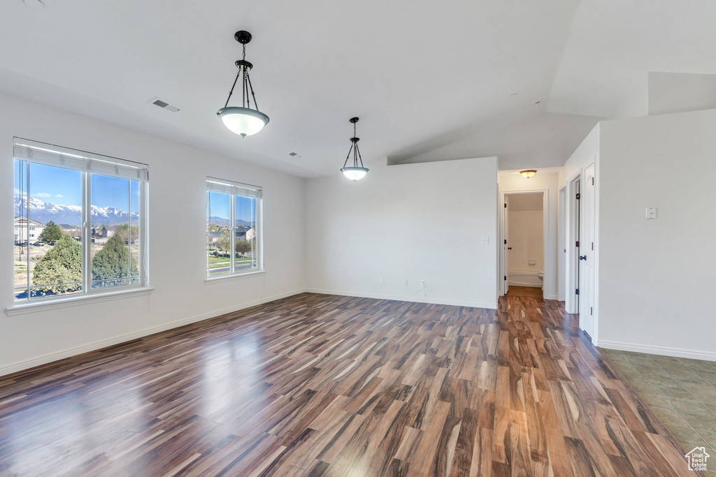 Interior space with baseboards, visible vents, wood finished floors, and lofted ceiling