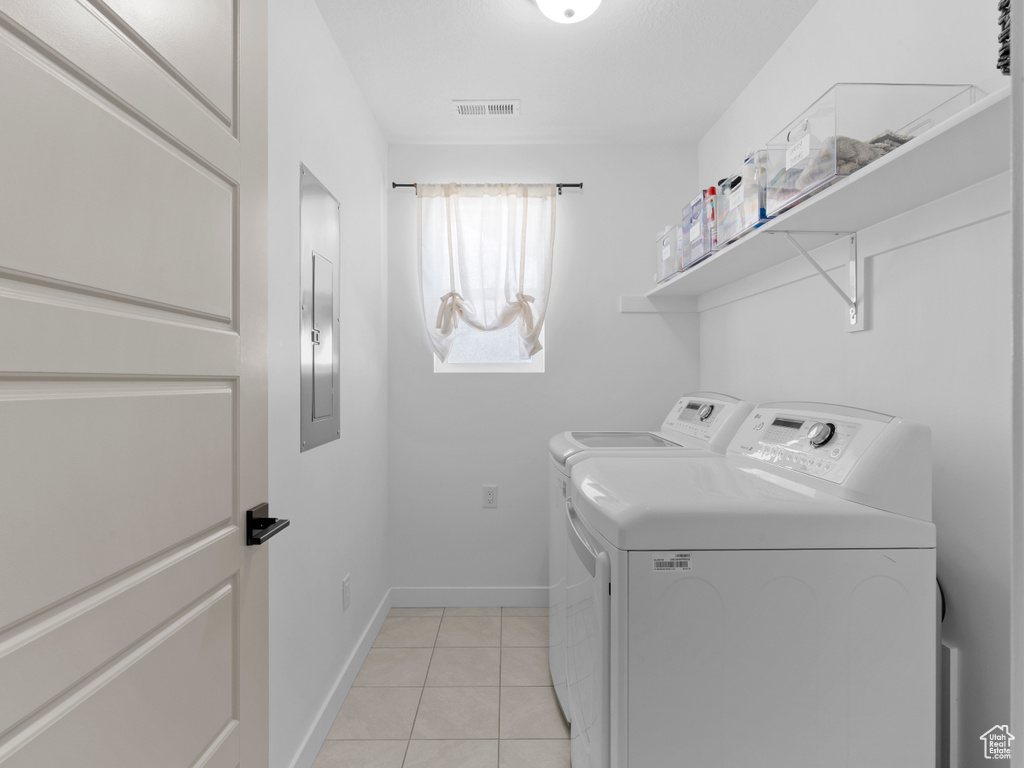 Laundry area with laundry area, visible vents, washer and dryer, baseboards, and light tile patterned floors