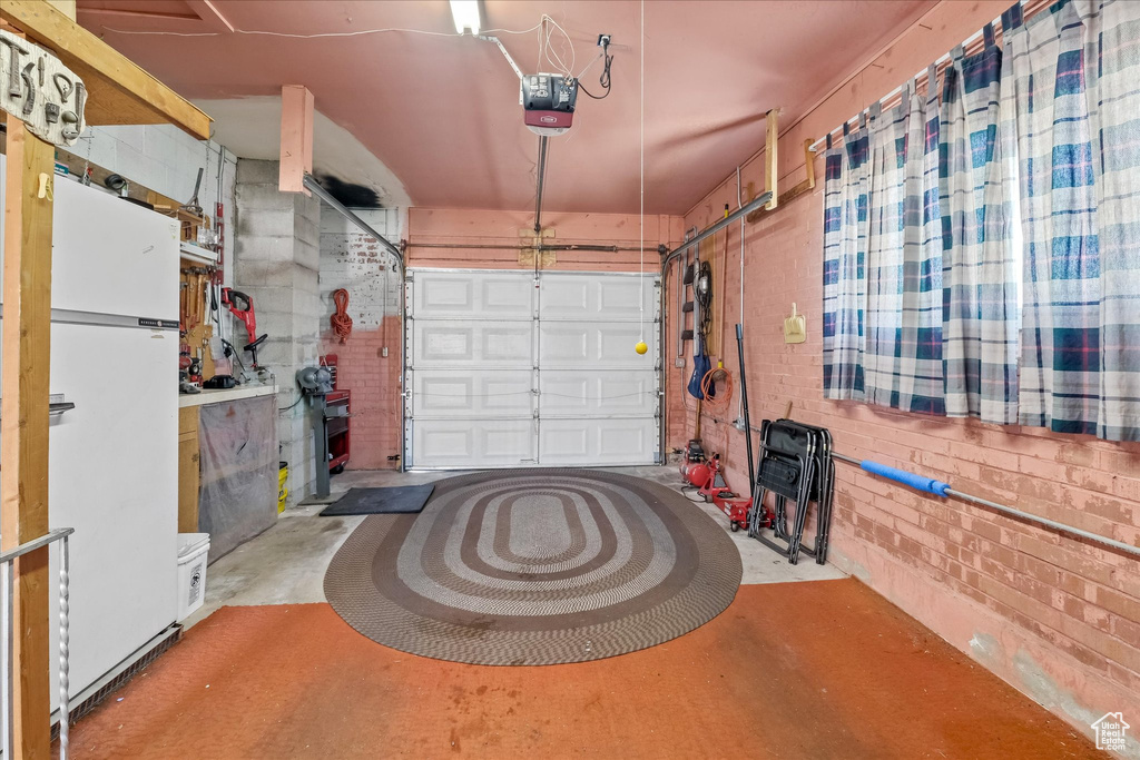 Garage with freestanding refrigerator and a garage door opener