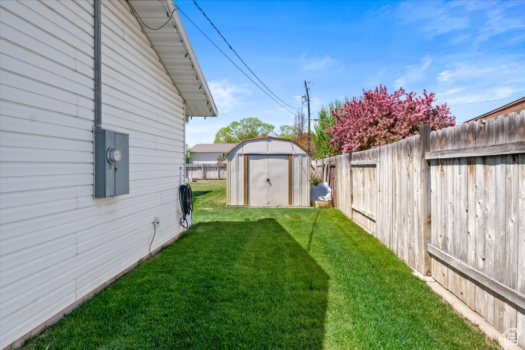 View of yard with a storage shed, an outdoor structure, and a fenced backyard