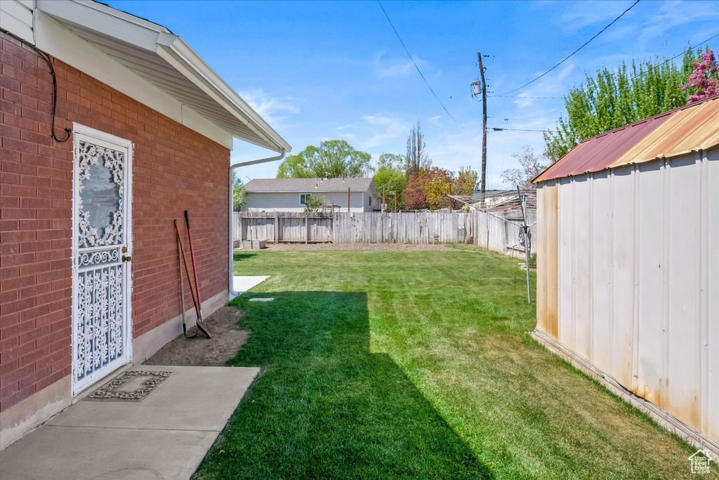 View of yard featuring an outbuilding, a fenced backyard, and a shed