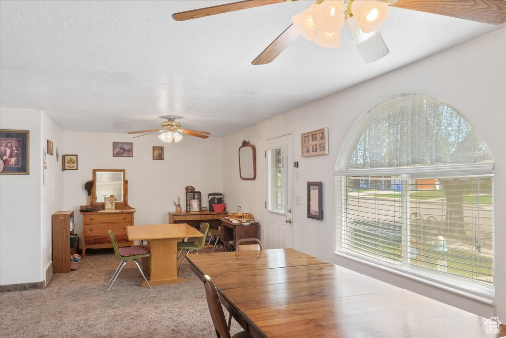 Dining area featuring ceiling fan and light colored carpet