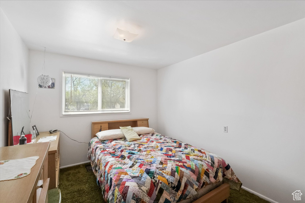 Bedroom featuring baseboards and dark colored carpet