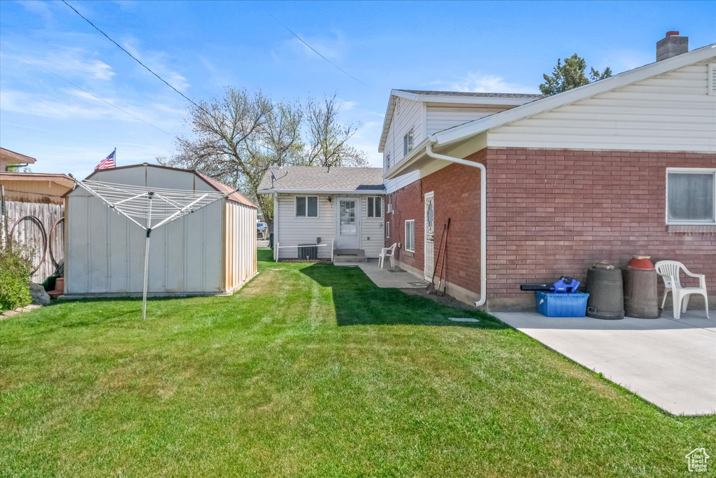 View of yard with an outbuilding, central air condition unit, a storage unit, a patio, and entry steps