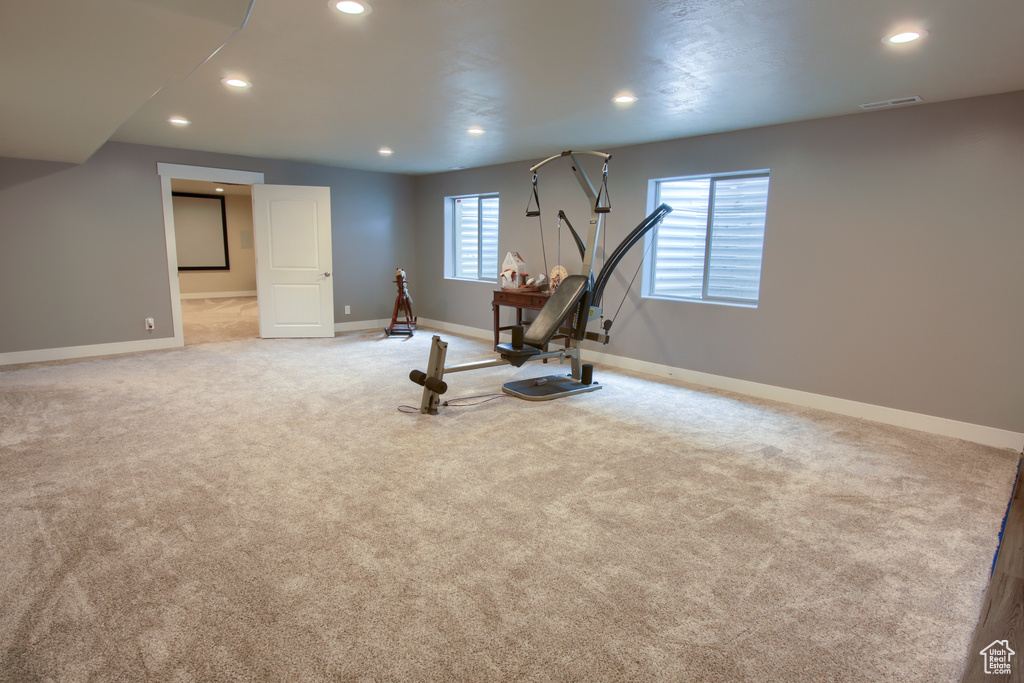 Exercise area featuring baseboards, recessed lighting, visible vents, and light carpet