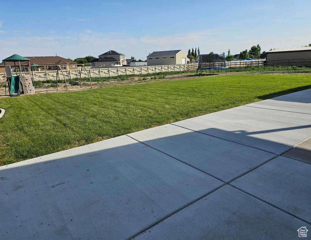 View of yard featuring a trampoline, a patio area, and a playground
