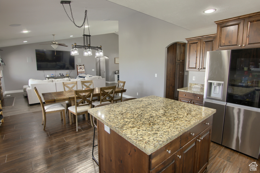 Kitchen featuring ceiling fan, arched walkways, baseboards, stainless steel fridge, and recessed lighting