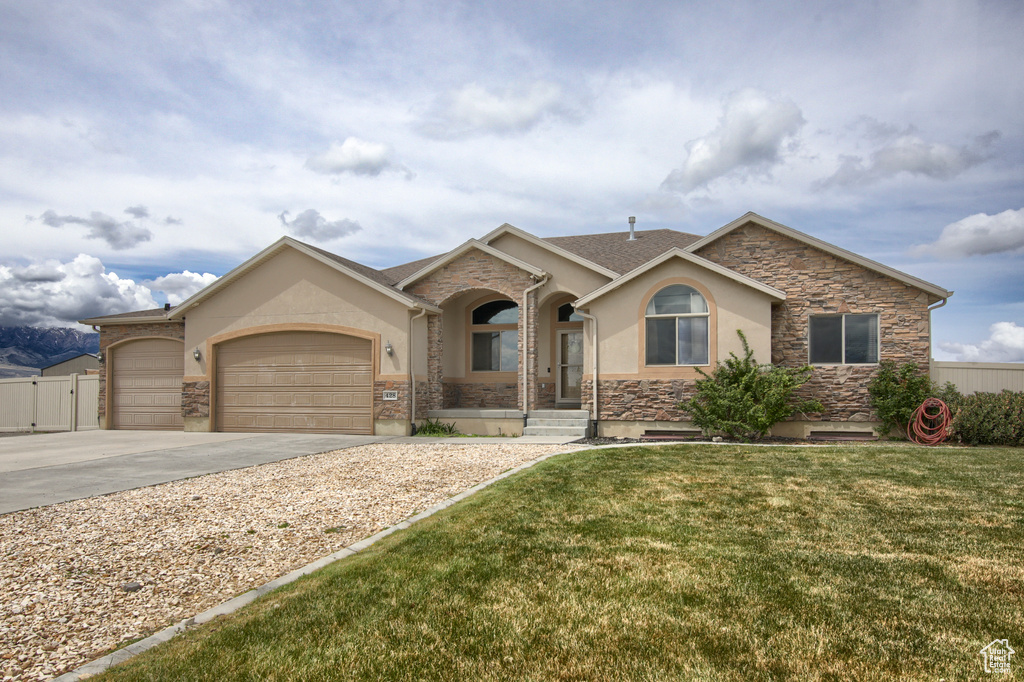 Single story home featuring a garage, stucco siding, concrete driveway, and stone siding