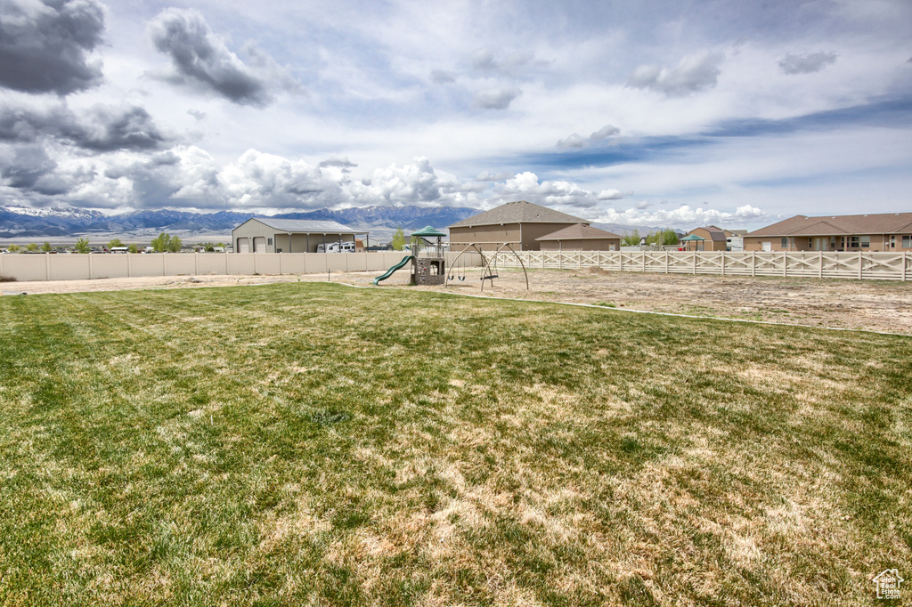 View of yard featuring fence and a playground