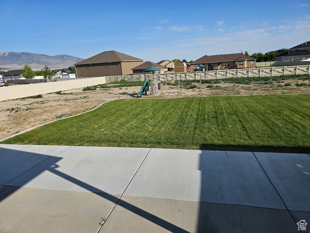 View of yard with a playground, a patio area, and a residential view