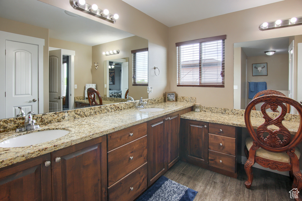 Ensuite bathroom with a sink, ensuite bathroom, double vanity, and wood finished floors