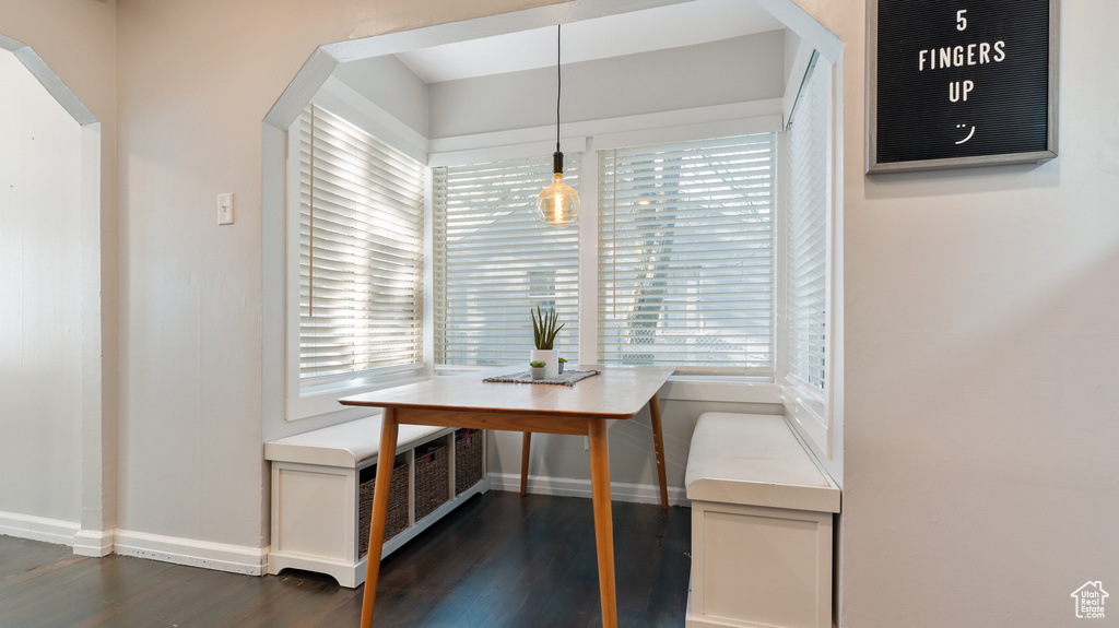 Dining area featuring plenty of natural light, arched walkways, breakfast area, and dark wood-style floors