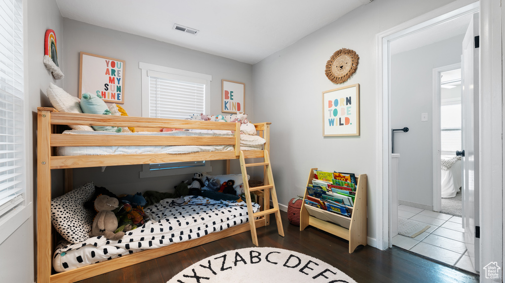 Bedroom featuring visible vents, baseboards, and wood finished floors