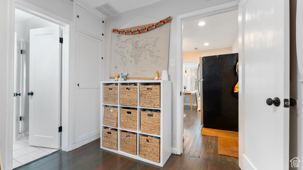 Hallway with recessed lighting, hardwood / wood-style flooring, and visible vents