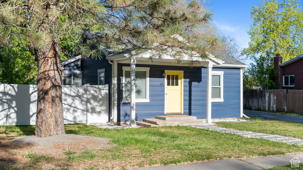 Bungalow-style home featuring fence and a front yard