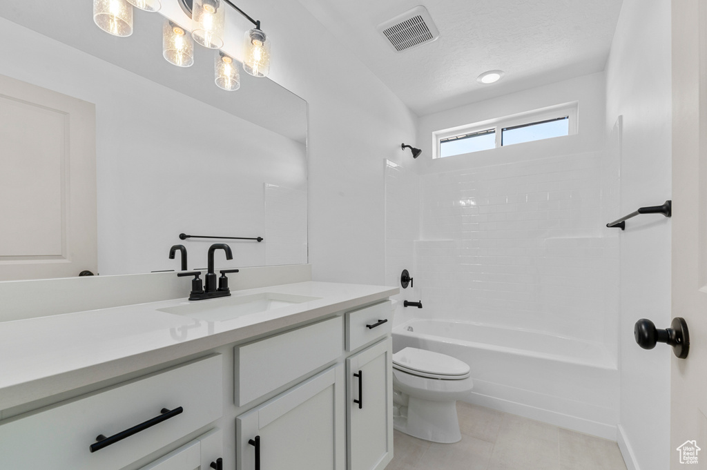 Bathroom featuring toilet, visible vents, washtub / shower combination, and vanity
