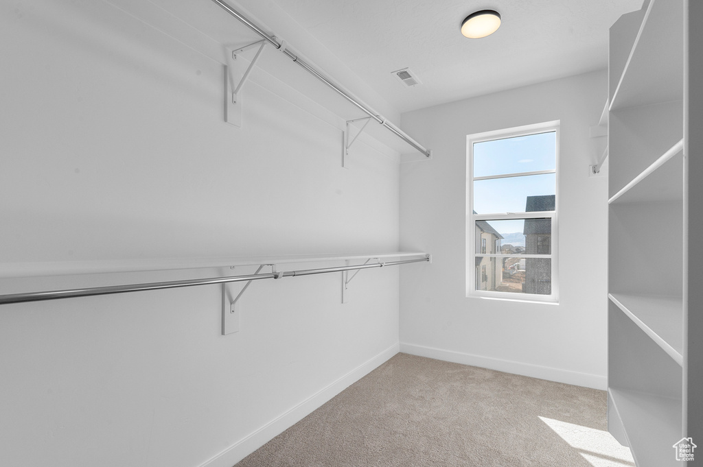 Walk in closet with light colored carpet and visible vents