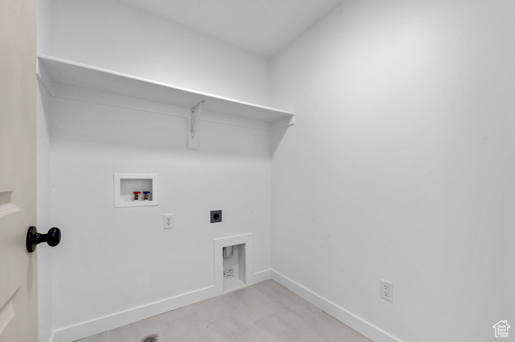 Laundry area with laundry area, light tile patterned flooring, baseboards, electric dryer hookup, and washer hookup
