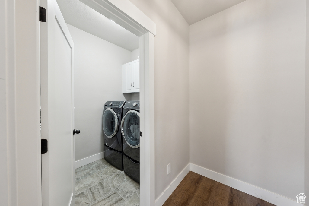 Laundry area with cabinet space, washing machine and clothes dryer, and baseboards