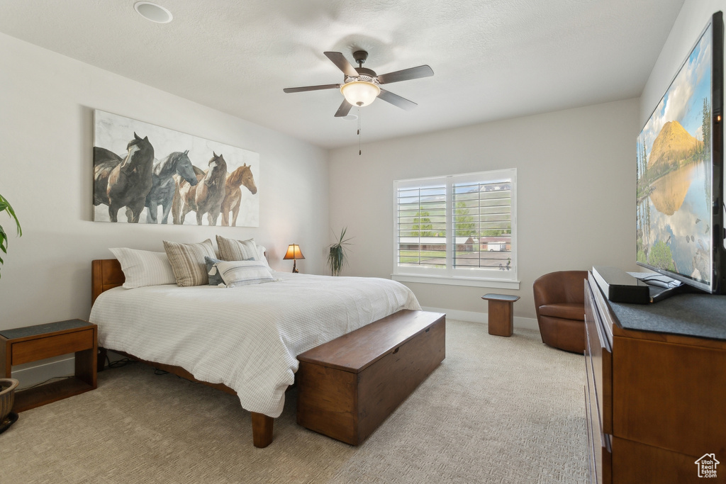 Bedroom featuring a ceiling fan and light colored carpet