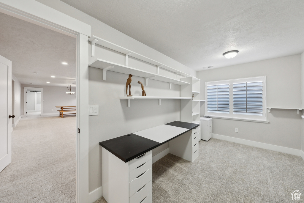 Walk in closet with light carpet