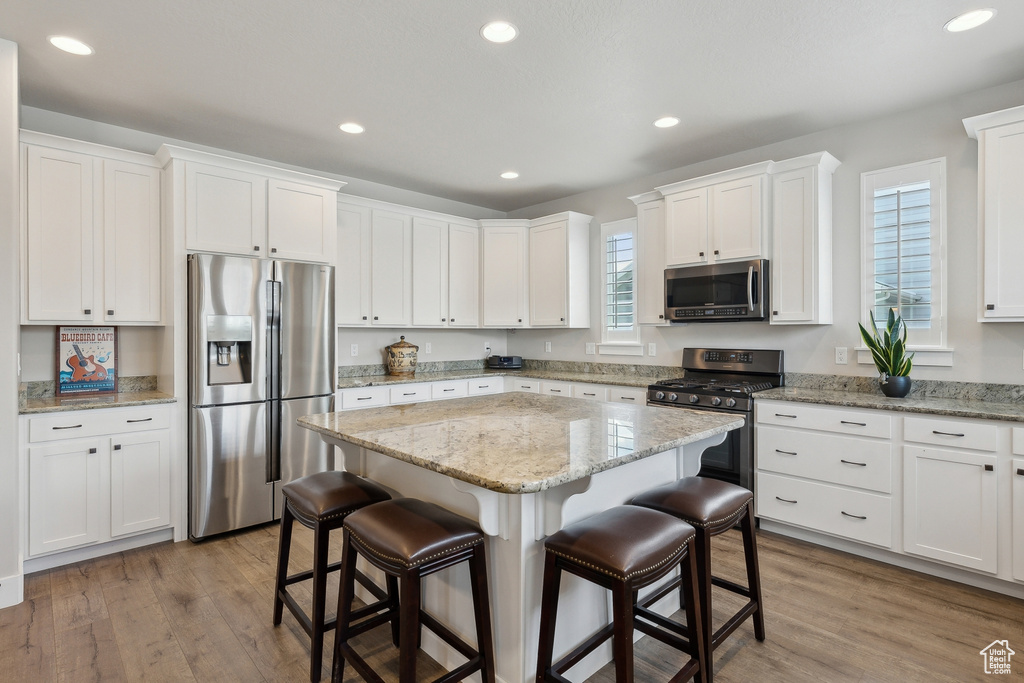 Kitchen featuring appliances with stainless steel finishes, a kitchen bar, plenty of natural light, and a kitchen island