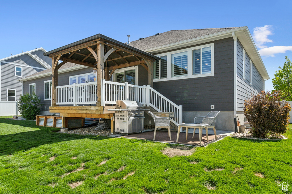 Back of house with a yard, a gazebo, and a deck