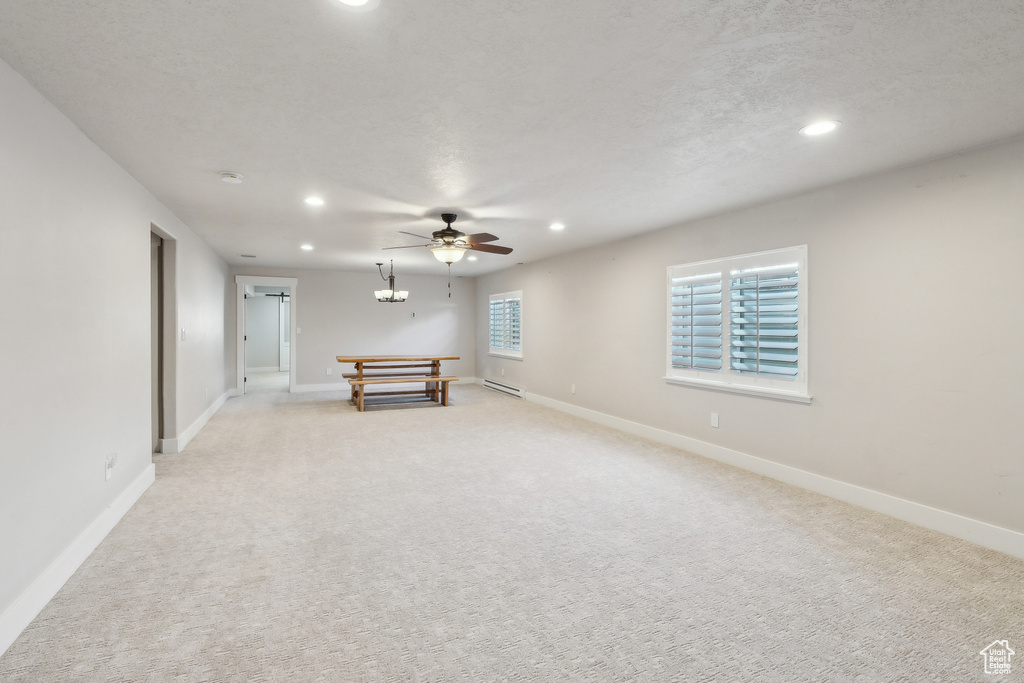 Rec room with light colored carpet, recessed lighting, a baseboard heating unit, and baseboards