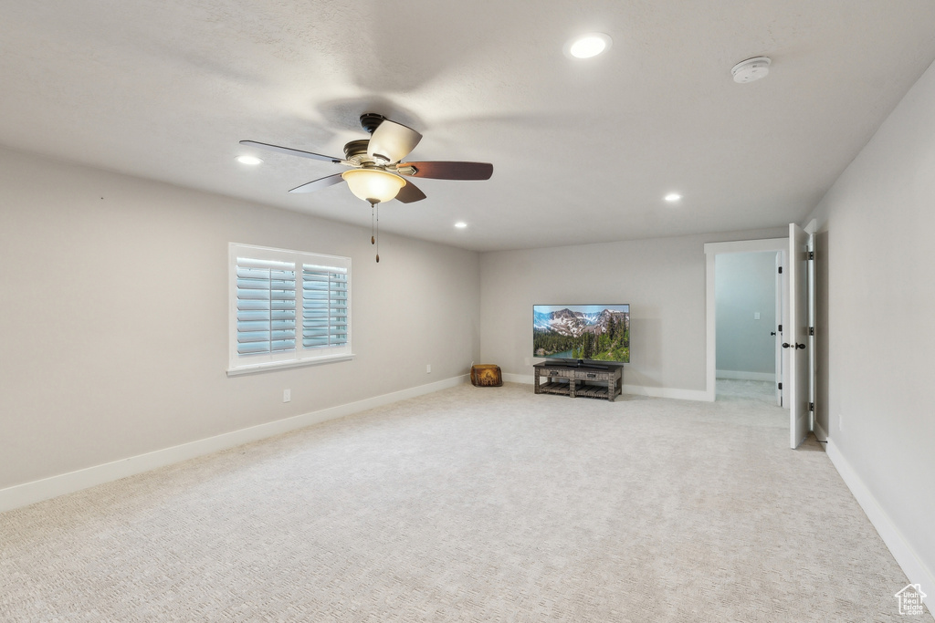 Carpeted living area featuring baseboards, recessed lighting, and a ceiling fan