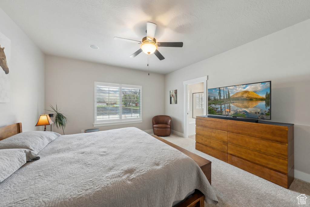 Carpeted bedroom featuring ceiling fan and baseboards