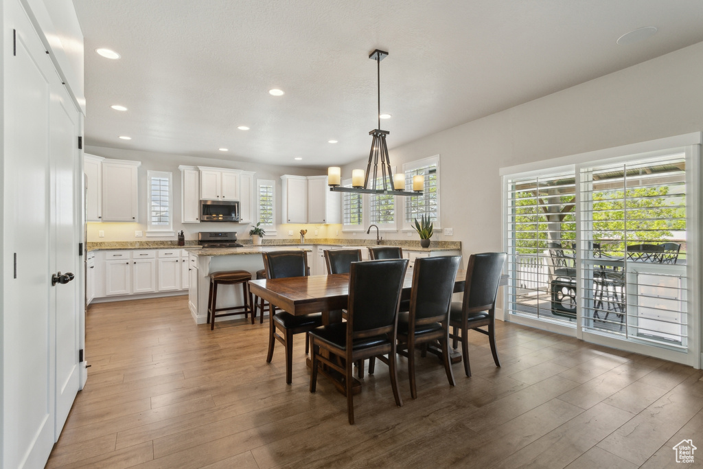 Dining room featuring wood finished floors, recessed lighting, and plenty of natural light