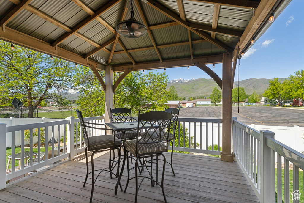Deck featuring a mountain view, a gazebo, and outdoor dining area