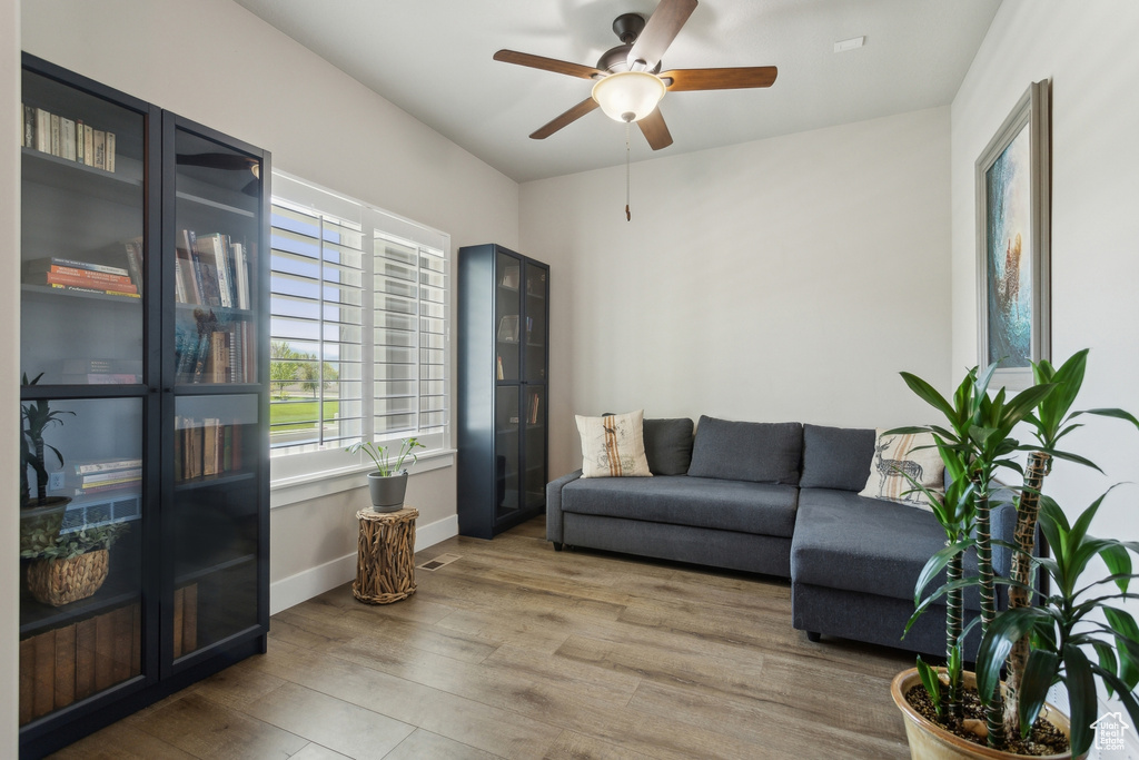 Living room featuring wood finished floors, ceiling fan, and baseboards