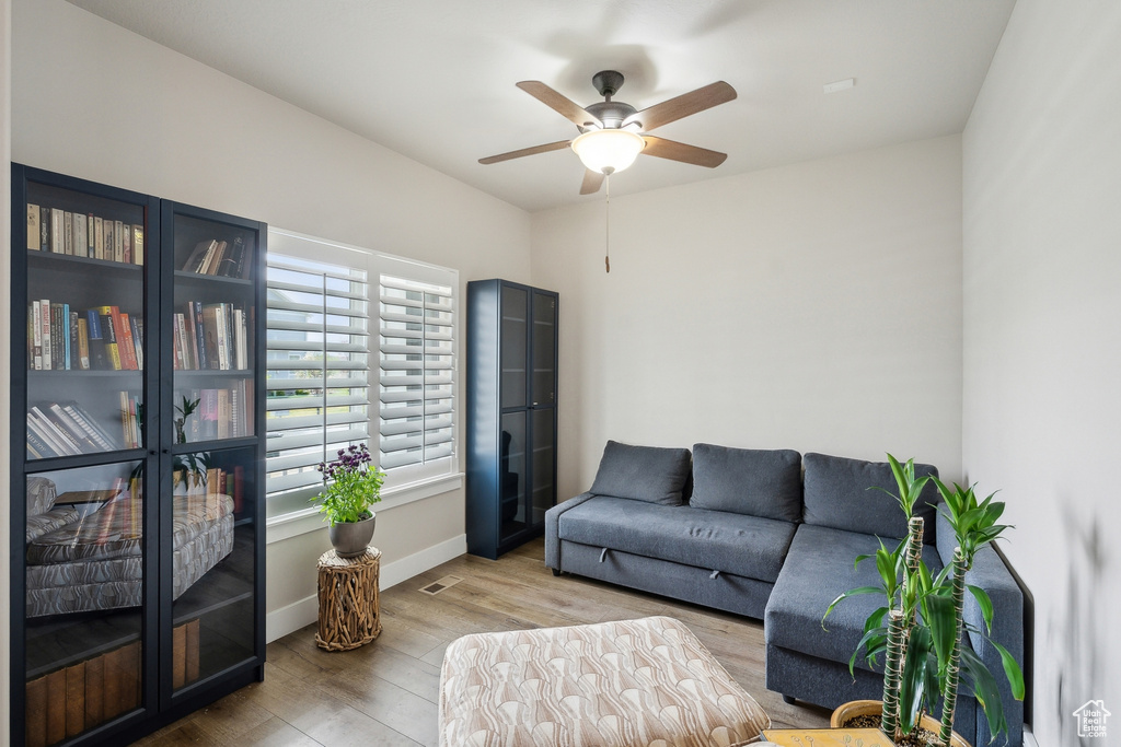 Living room featuring ceiling fan, wood finished floors, and baseboards