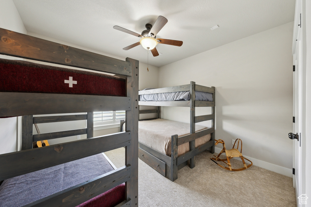 Bedroom with ceiling fan, carpet flooring, and baseboards