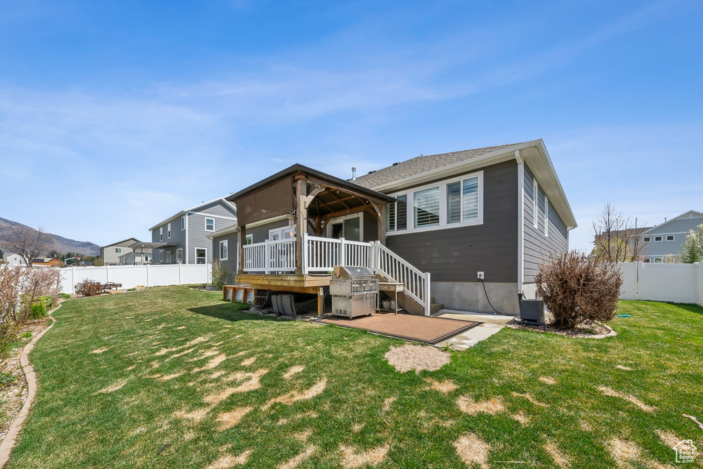 Back of house with a deck, a fenced backyard, a yard, and a patio area